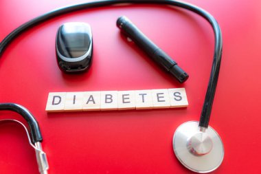 Tıbbi steteskoplu glikoz ölçer, diyabet konsepti, sağlıklı yaşam tarzları ve beslenme. Diyabet Metni. Kırmızı arkaplan