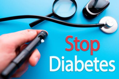 Diyabet konsepti. Glukometre ya da glikoz ölçer, şeker ve kaşık mavi arka planda DUR DIABETES. Sağlık Hizmetleri.