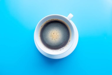 Kahve fincanındaki koyu kahve mavi arka planda izole edilmiş. kırpma yolu ile.