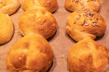 Kahvaltı için ev yapımı ekmek ruloları ya da çörekler masadaki kağıt üzerinde taze, seçilmiş odak, dar alan derinliği