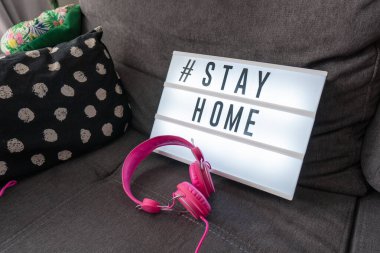 Coronavirus ev ışık kutusu tabelası # STAYHOME ev kanepede rahat bir şekilde parlıyor. COVID-19 metni evde kalarak kendini izolasyona teşvik ediyor.