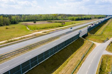  Güzel bir yaz akşamında yoğun otoyolda giden arabalar ve kamyonlar. İnsanlar altın gün batımında kalabalık otobanda seyahat ediyorlar.