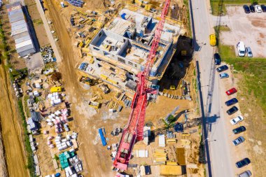 Kule görüntüsü, vinç kaldırma ve inşaat halindeki uzun apartmanın beton iskeleti. Kentsel kalkınma ve gayrimenkul büyüme kavramı.