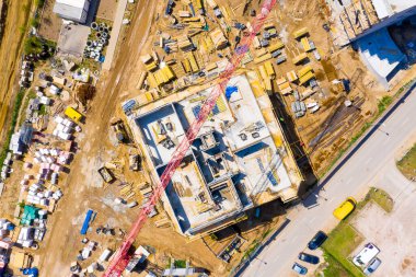 Kule görüntüsü, vinç kaldırma ve inşaat halindeki uzun apartmanın beton iskeleti. Kentsel kalkınma ve gayrimenkul büyüme kavramı.