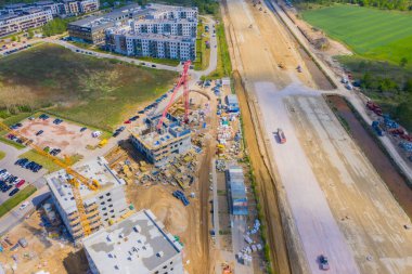 Şehrin yerleşim bölgesinde yeni apartmanlar inşa ediliyor. Kule vinçleri olan bir inşaat alanı. hava görünümü