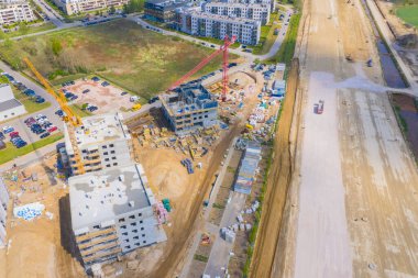 Şehrin yerleşim bölgesinde yeni apartmanlar inşa ediliyor. Kule vinçleri olan bir inşaat alanı. hava görünümü