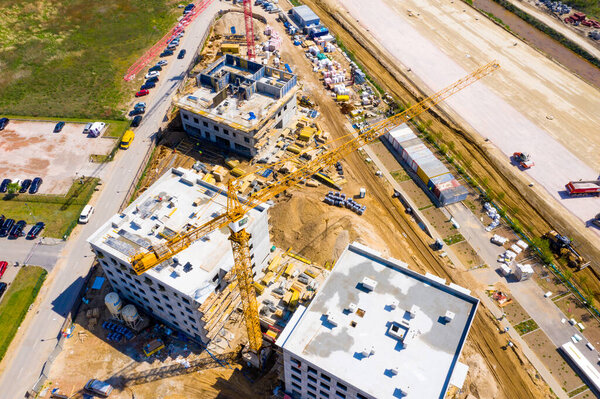 Aerial Bird Eye View Of a Construction Site Building Cranes Looking Down Industrial Machinery Area around Residential Urban Apartments