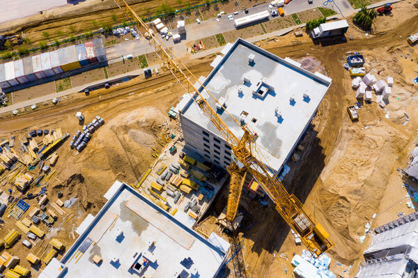 Aerial Bird Eye View Of a Construction Site Building Cranes Looking Down Industrial Machinery Area around Residential Urban Apartments
