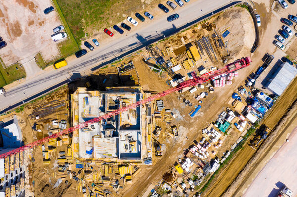 Construction site with cranes. Construction workers are building. Aerial view of construction site of residential area buildings with cranes