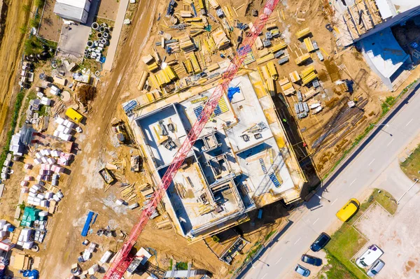 Aerial view of tower lifting crane and concrete frame of tall apartment residential building under construction in a city. Urban development and real estate growth concept. — Stock Image Aerial View Tower Lifting Crane Concrete Frame Tall Apartment Residential Stock Photo