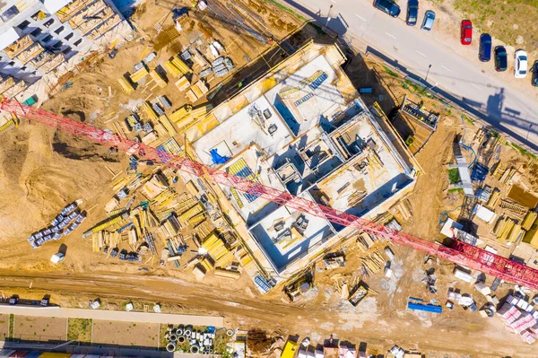 Aerial view of tower lifting crane and concrete frame of tall apartment residential building under construction in a city. Urban development and real estate growth concept. — Stock Image Aerial View Tower Lifting Crane Concrete Frame Tall Apartment Residential Stock Image