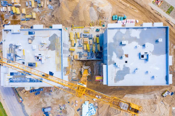 Aerial view of tower lifting crane and concrete frame of tall apartment residential building under construction in a city. Urban development and real estate growth concept. — Stock Image Aerial View Tower Lifting Crane Concrete Frame Tall Apartment Residential Royalty Free Stock Photos