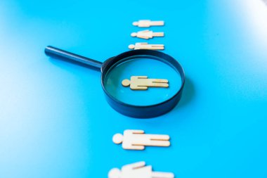 Çalışan insan kaynakları konsepti - mavi arka planda soyut çalışanı olan büyüteç. Kapat..