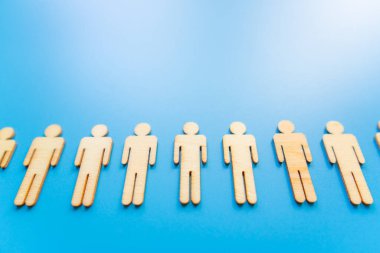 Mavi arka planda ahşap figürler takım oluşturmanın sembolü. Organizasyon grubu insanları iş başında. İşbirliği ve ortaklık.