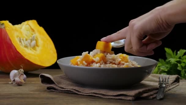 Womens hands decorating the dish. Pumpkin risotto — Stock Video