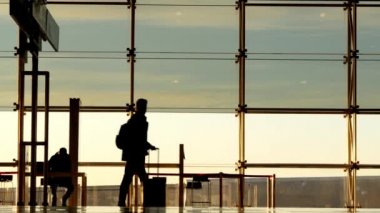 Bir çocuk annesi Barcelona'da Uluslararası Havaalanı. İnsan siluetleri