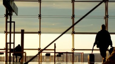 Bir çocuk annesi Barcelona'da Uluslararası Havaalanı. İnsan siluetleri