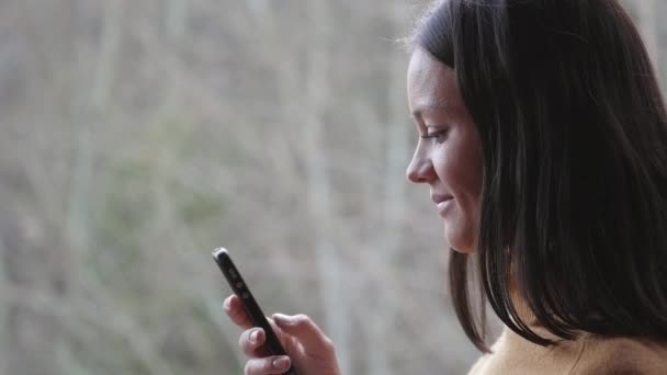 Belle femme avec smartphone dans la forêt — Video
