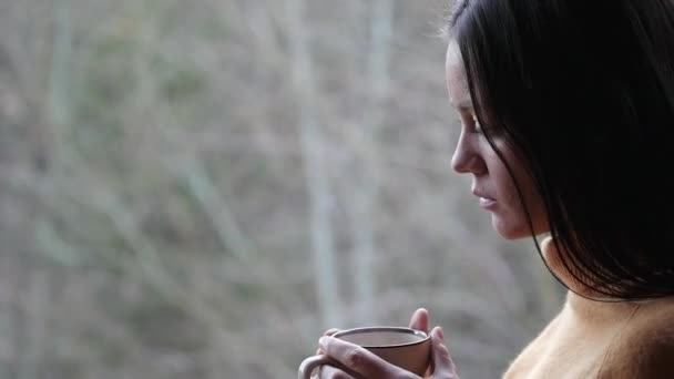 Mujer triste con taza de café en el fondo del bosque — Vídeos de Stock