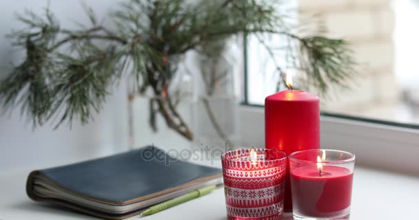 Velas y cuaderno en un alféizar de ventana — Vídeos de Stock