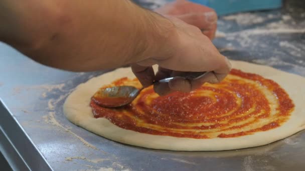 Kocken sprider tomatpuré på italiensk pizza — Stockvideo