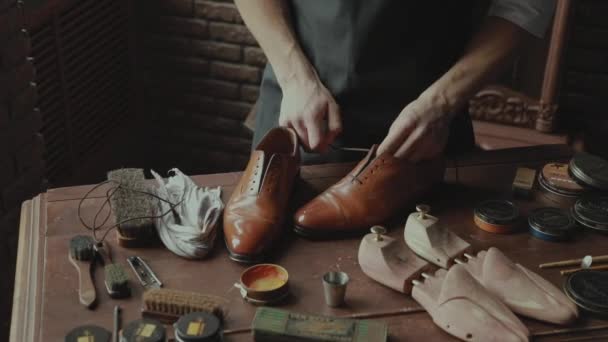 The master inserts the shoelaces into the shoes — Stock Video
