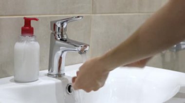 Koronavirüs salgınını önlemek için ellerini çorbayla yıkayan kadın.