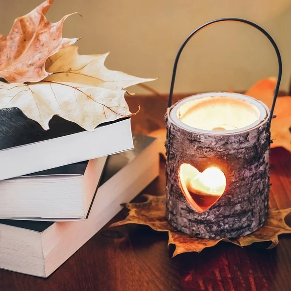 Books and candle holder with autumn leaves — Stock Photo, Image