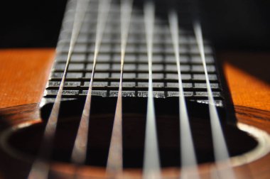 Klasik gitar. Yaylı çalgı sesleri veren. Fretboard, dizeleri ve hangileriyle