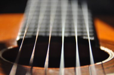 Klasik gitar. Yaylı çalgı sesleri veren. Fretboard, dizeleri ve hangileriyle