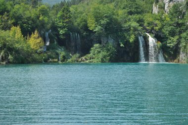 Yüksek şelale, gölün içine kayaların üzerinden akan su. Milli Park Plitvice Gölleri. Hırvatistan'da turizm.