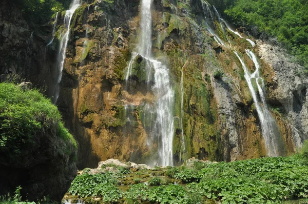 Высокий водопад, вода, текущая из скал в озеро. Национальный парк Плитвицкие озера. Туризм в Хорватии . — стоковое фото