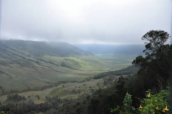 Escalando el volcán Bromo, Indonesia. Nubes oscurecieron el cráter y el valle verde — Foto de Stock