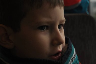 Çocuk pencerenin altından şehri izliyor.