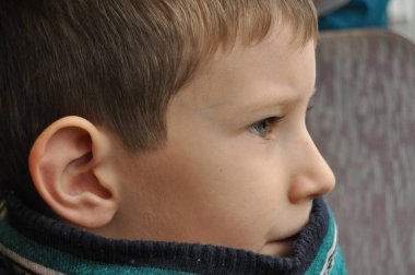 Çocuk pencerenin altından şehri izliyor.