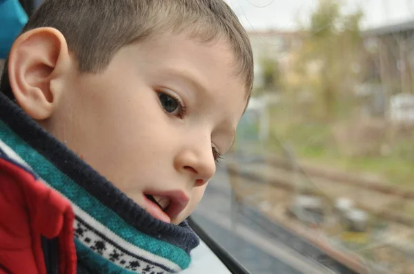 Junge beobachtet die Stadt durch das Fenster der U-Bahn — Stockfoto