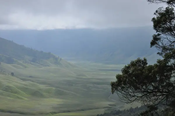 Escalando el volcán Bromo, Indonesia. Nubes oscurecieron el cráter y el valle verde — Foto de Stock