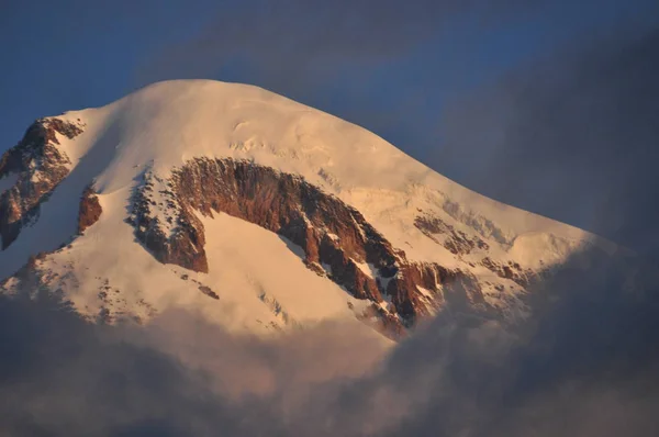 雪をかぶった山々 カズベク夜明けと下谷教会シエテの三位一体があります。グルジア. — ストック写真
