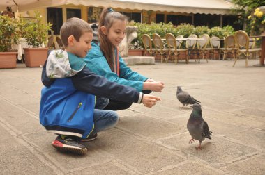 Venedik, bir yaya Caddesi üzerinde çocuklar tarafından ekmek kırıntısı beslenen güvercinler.