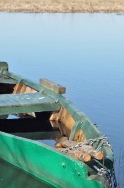 Kürek teknesi kıyıya demirlemiş. Nehirde bahar. Yüzen.