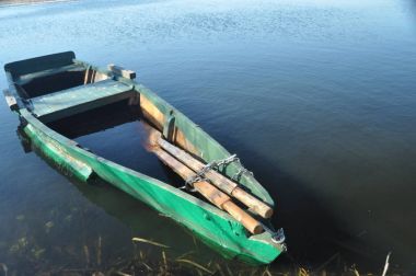 Kürek teknesi kıyıya demirlemiş. Nehirde bahar. Yüzen.