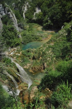 Yüksek şelale, gölün içine kayaların üzerinden akan su. Milli Park Plitvice Gölleri. Hırvatistan'da turizm.