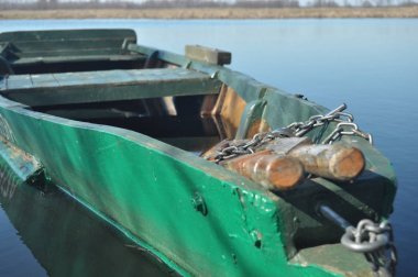 Kürek teknesi kıyıya demirlemiş. Nehirde bahar. Yüzen.