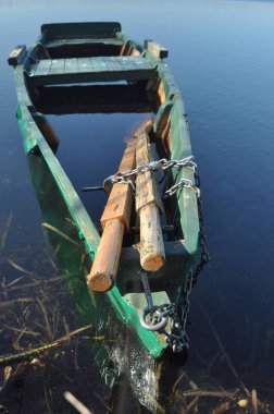 Kürek teknesi kıyıya demirlemiş. Nehirde bahar. Yüzen.