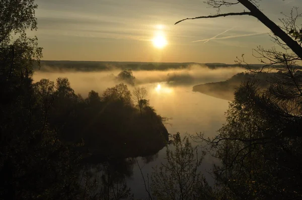 Sunrise. The river in the mist. A view of the meadows and the river in the morning.