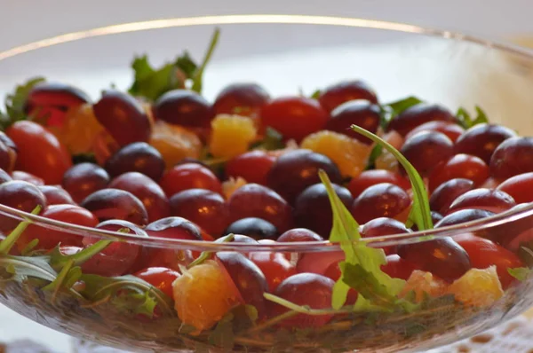 Salad in a glass dish. Rocket salad with grapes.