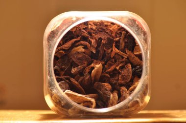 Kapsayıcıdan dökülmesini kurutulmuş mantar. Gıda katkı maddeleri. Orman meyveleri. Sonbaharda hasat.