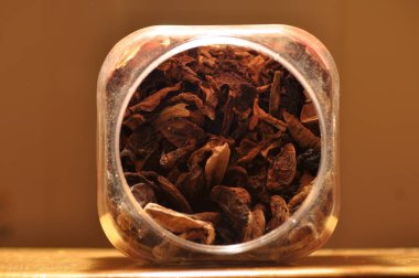 Kapsayıcıdan dökülmesini kurutulmuş mantar. Gıda katkı maddeleri. Orman meyveleri. Sonbaharda hasat.