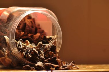 Kapsayıcıdan dökülmesini kurutulmuş mantar. Gıda katkı maddeleri. Orman meyveleri. Sonbaharda hasat.