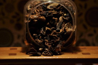 Kapsayıcıdan dökülmesini kurutulmuş mantar. Gıda katkı maddeleri. Orman meyveleri. Sonbaharda hasat.